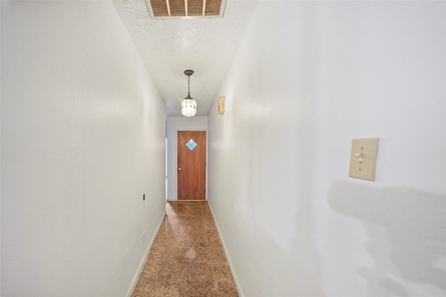 doorway to outside with carpet floors and a textured ceiling