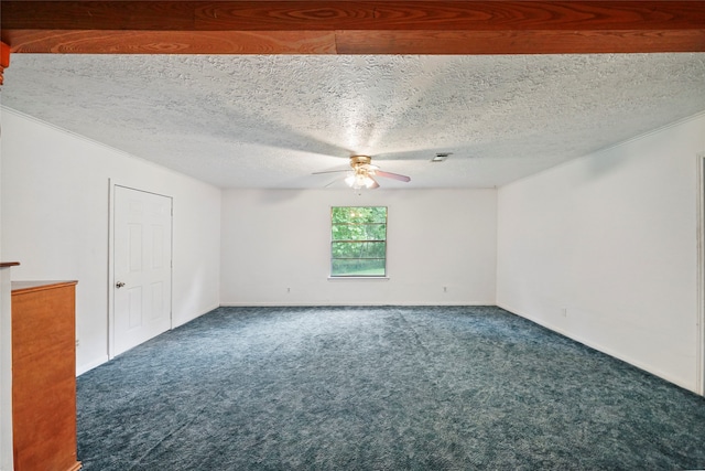 spare room with ceiling fan, a textured ceiling, and dark colored carpet