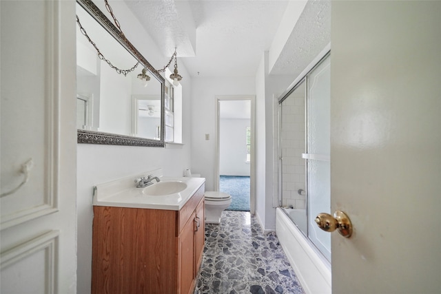 full bathroom with vanity, combined bath / shower with glass door, a textured ceiling, and toilet