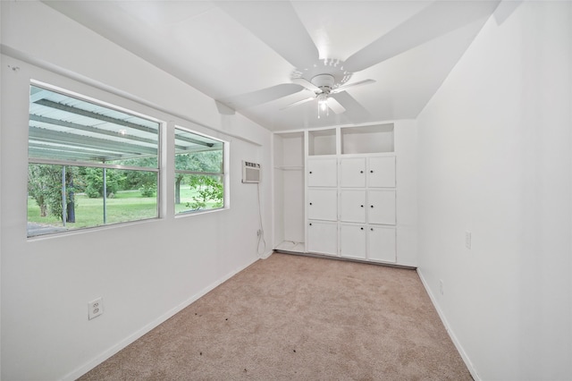 unfurnished bedroom featuring a wall mounted air conditioner, light carpet, and ceiling fan