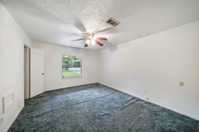 carpeted empty room featuring ceiling fan and a textured ceiling