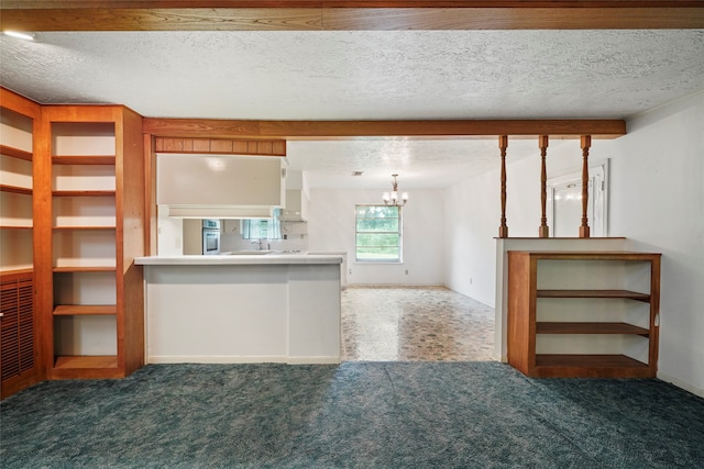 interior space featuring an inviting chandelier, stainless steel oven, a textured ceiling, and dark colored carpet