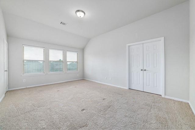 empty room with carpet flooring and vaulted ceiling