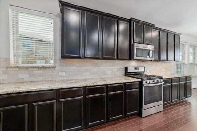 kitchen featuring tasteful backsplash, dark hardwood / wood-style flooring, and appliances with stainless steel finishes