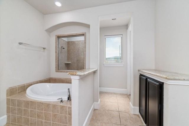 bathroom featuring tile patterned floors and independent shower and bath