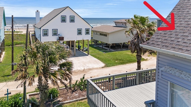 wooden deck with central air condition unit, a lawn, and a water view