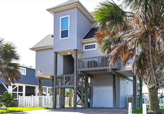 rear view of property featuring a garage and a balcony