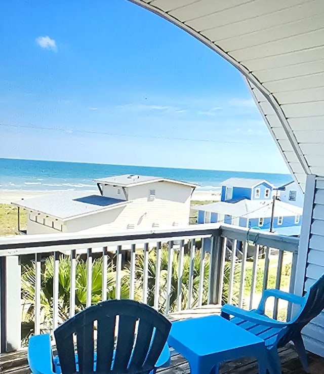 balcony with a water view and a beach view