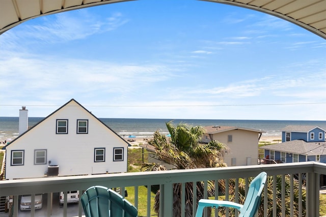 balcony featuring central AC unit, a water view, and a view of the beach