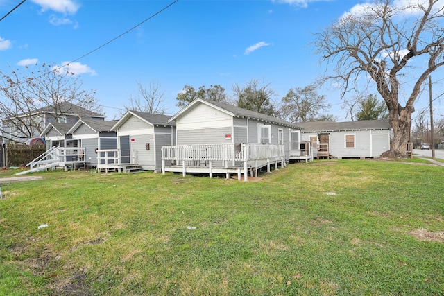 rear view of property featuring a yard and a wooden deck