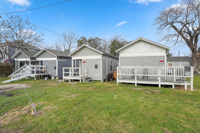 rear view of house with a yard and a wooden deck