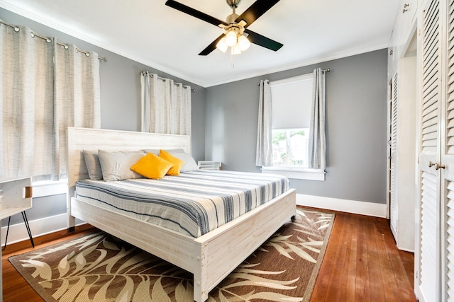 bedroom featuring crown molding, dark hardwood / wood-style floors, and ceiling fan