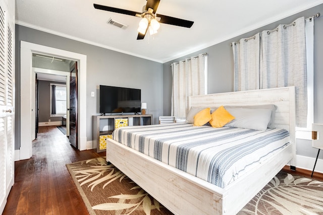 bedroom featuring dark hardwood / wood-style flooring, ornamental molding, and ceiling fan