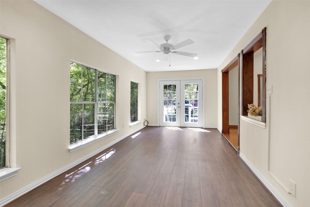 unfurnished sunroom featuring french doors, a healthy amount of sunlight, and ceiling fan