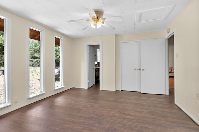 empty room featuring dark wood-type flooring, ceiling fan, and plenty of natural light