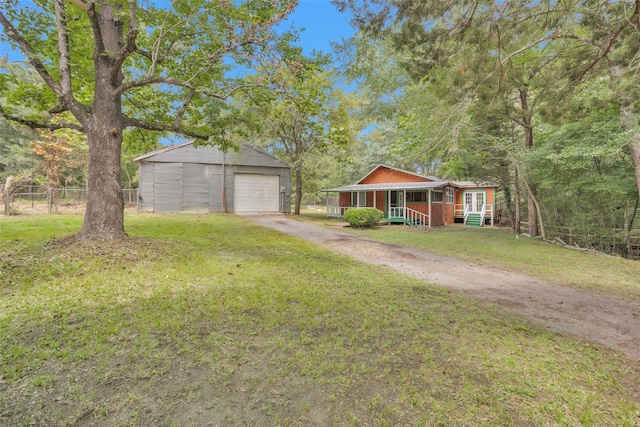 view of front of home featuring a front yard, an outdoor structure, and a garage