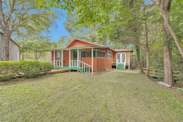 view of front of house with a wooden deck and a front lawn