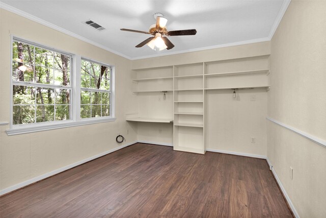 unfurnished bedroom featuring dark hardwood / wood-style flooring, ornamental molding, built in desk, and ceiling fan