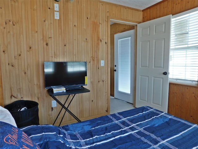 unfurnished bedroom featuring multiple windows and wooden walls