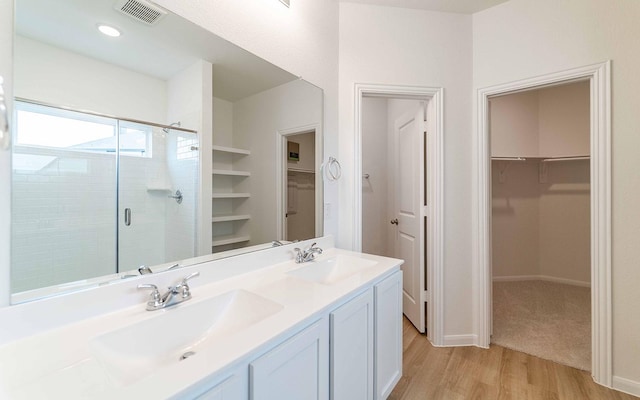 bathroom featuring a shower with door, vanity, and wood-type flooring