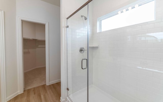 bathroom featuring hardwood / wood-style flooring and walk in shower