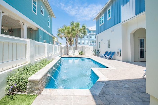 view of swimming pool with pool water feature and a patio