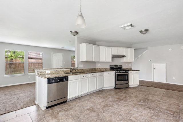 kitchen with stone counters, appliances with stainless steel finishes, white cabinetry, hanging light fixtures, and kitchen peninsula