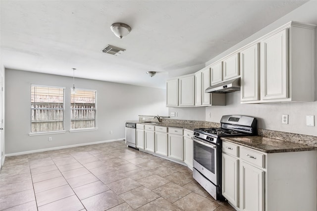 kitchen with sink, appliances with stainless steel finishes, hanging light fixtures, white cabinets, and light tile patterned flooring