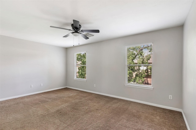 carpeted spare room featuring ceiling fan