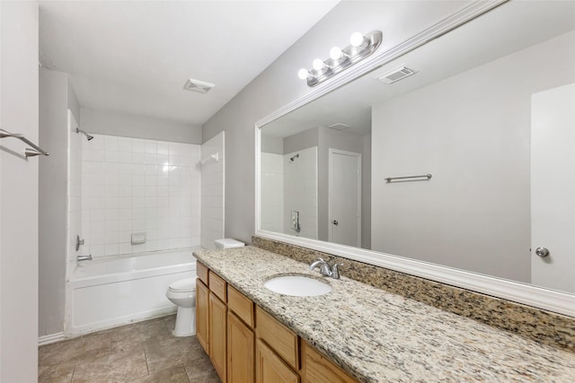 full bathroom with tiled shower / bath, vanity, and toilet