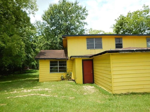 back of house featuring a lawn