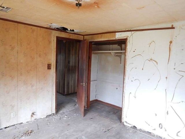 unfurnished bedroom with concrete flooring and a closet