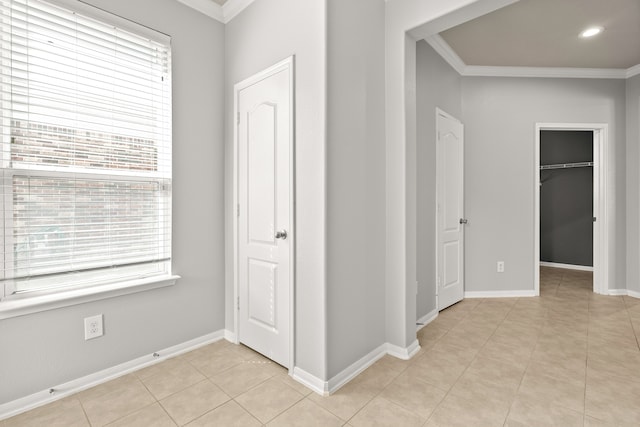 interior space with light tile patterned flooring, a wealth of natural light, and ornamental molding