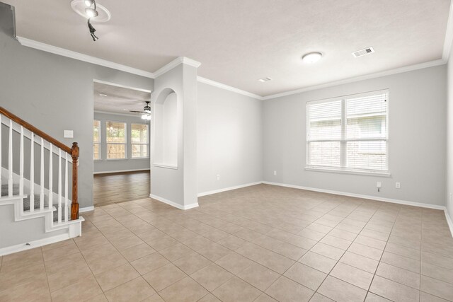 tiled empty room featuring crown molding and ceiling fan