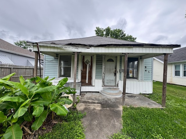 bungalow with a porch and a front lawn