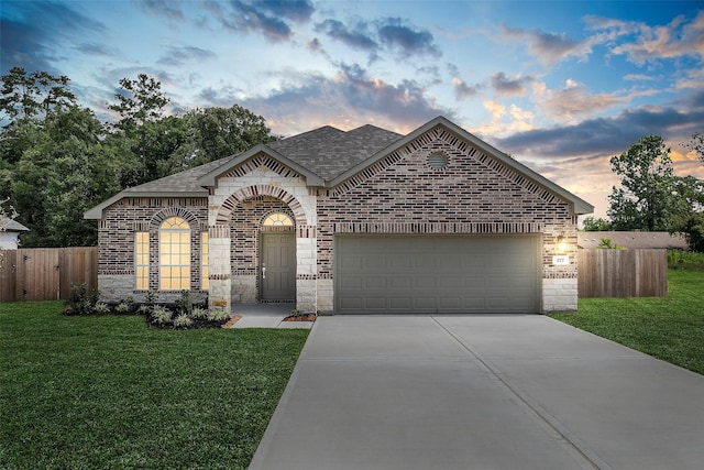 single story home featuring a garage and a lawn