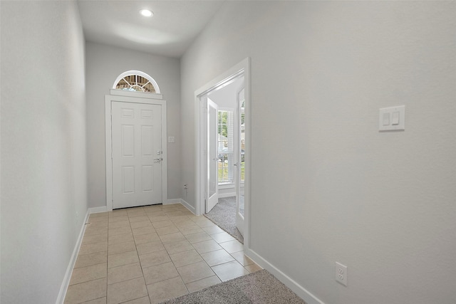 doorway to outside with light tile patterned flooring