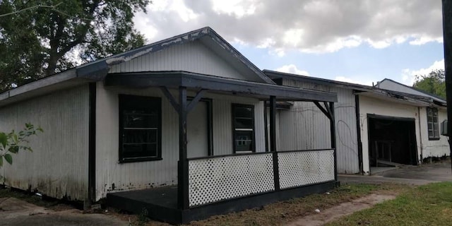 view of side of property featuring a porch and a garage