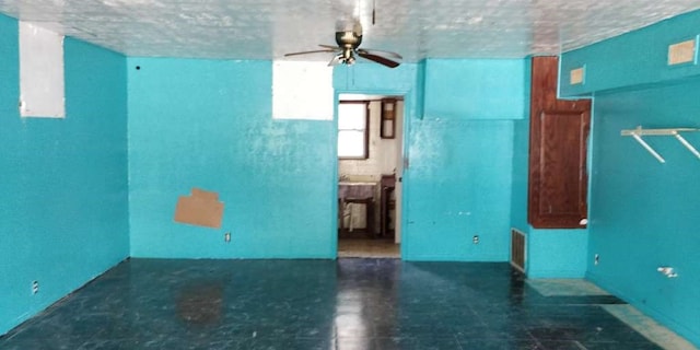 spare room featuring dark tile patterned floors and ceiling fan