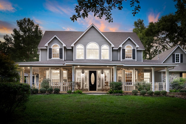 view of front of home with covered porch and a lawn