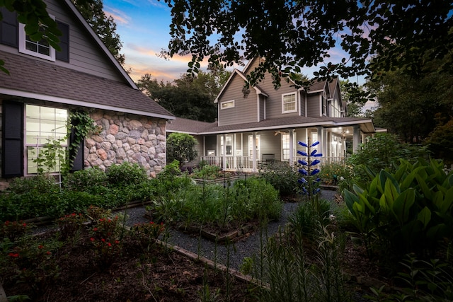 back house at dusk with a porch