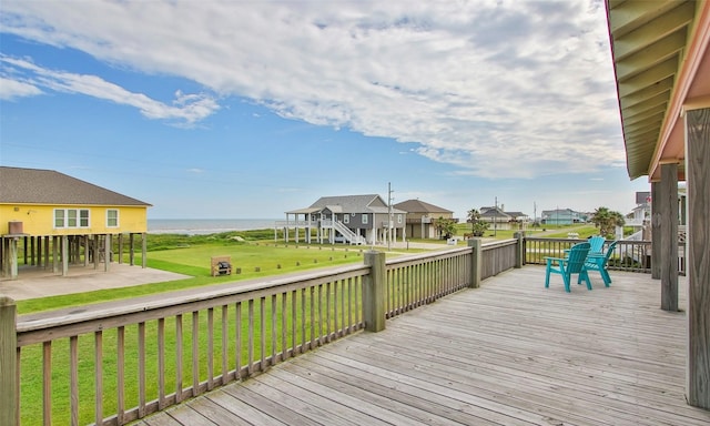 deck featuring a water view and a lawn