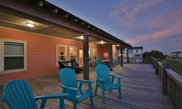 deck at dusk featuring ceiling fan