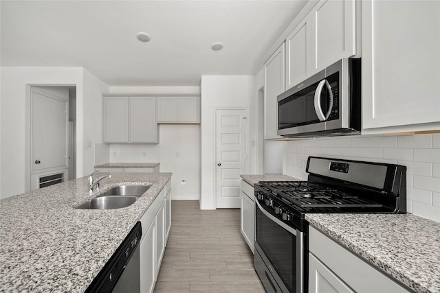 kitchen with sink, white cabinets, and appliances with stainless steel finishes