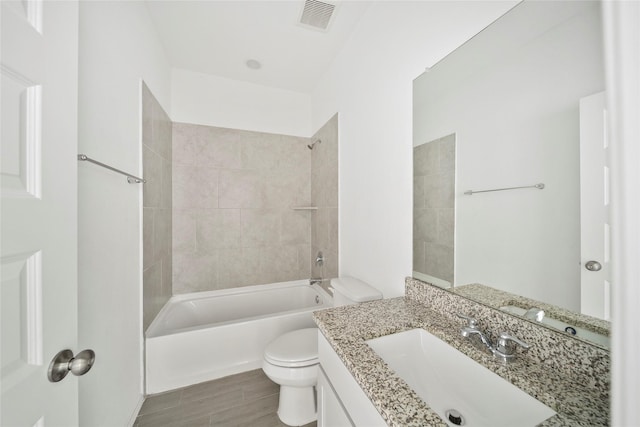 full bathroom with toilet, tiled shower / bath, and vanity