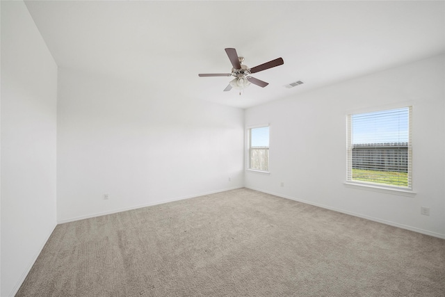 spare room with ceiling fan and light colored carpet