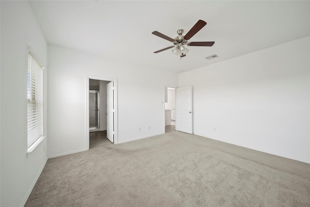 unfurnished bedroom featuring ceiling fan, carpet, and ensuite bath