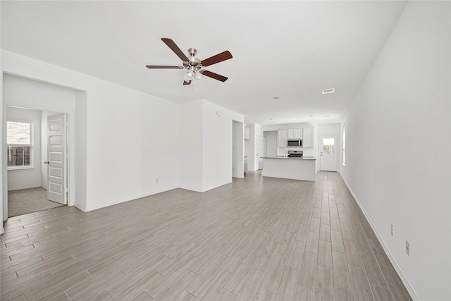 unfurnished living room with ceiling fan