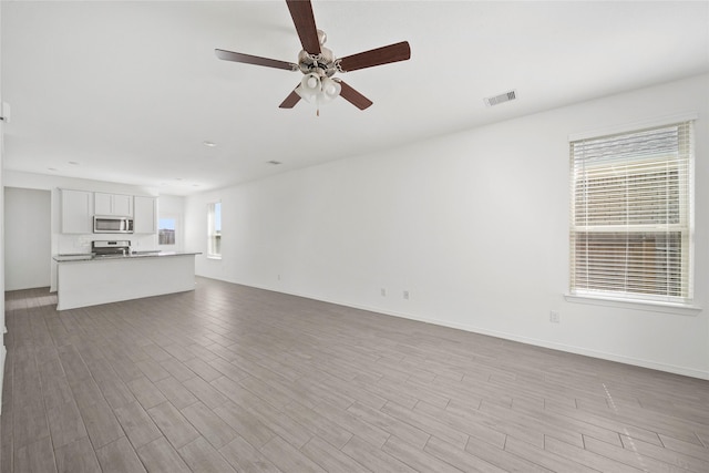 unfurnished living room with ceiling fan and light hardwood / wood-style floors