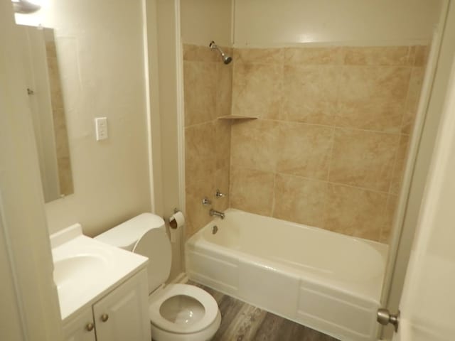 full bathroom featuring toilet, hardwood / wood-style floors, vanity, and tiled shower / bath combo